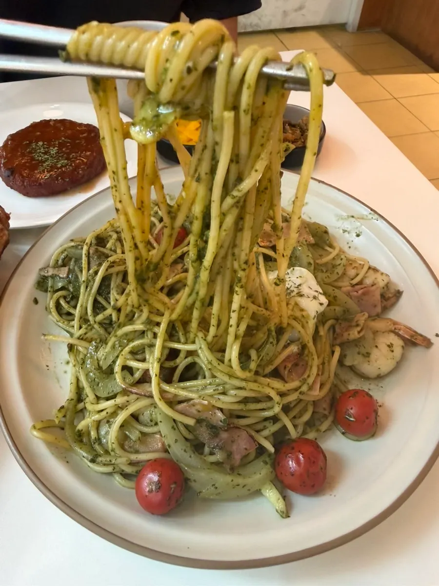 Noodles in the shrimp basil pasta with broken yolk mixed in