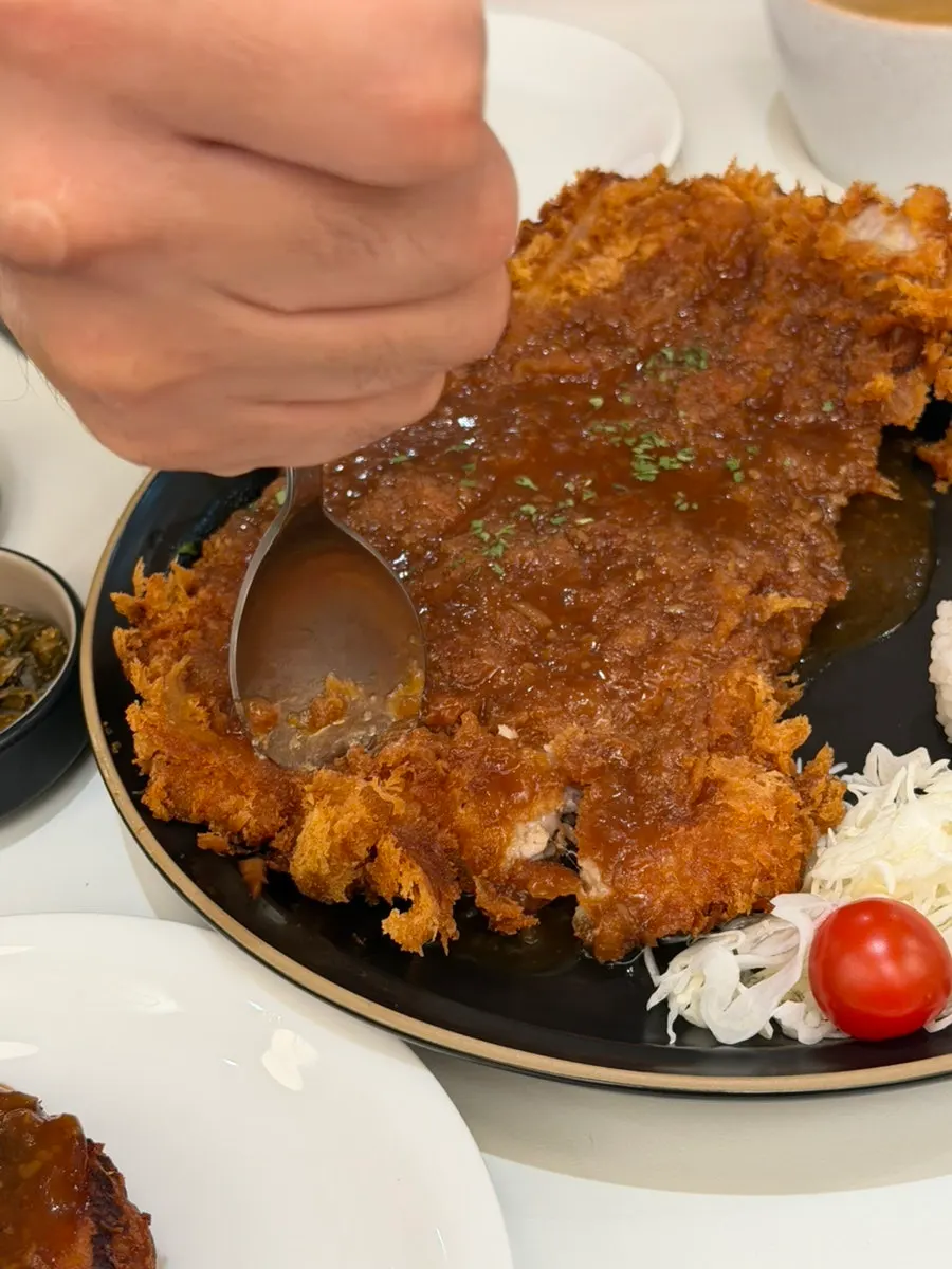 Full spread of futomaki, bone-in tonkatsu, and hamburg steak
