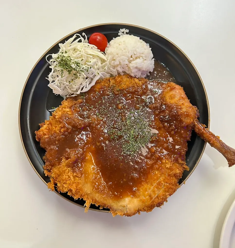 Cross-section of the thick bone-in tonkatsu cut with scissors