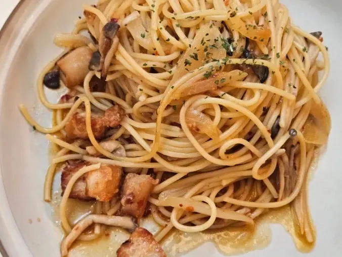 Side view of the pork jowl wild garlic oil pasta plate