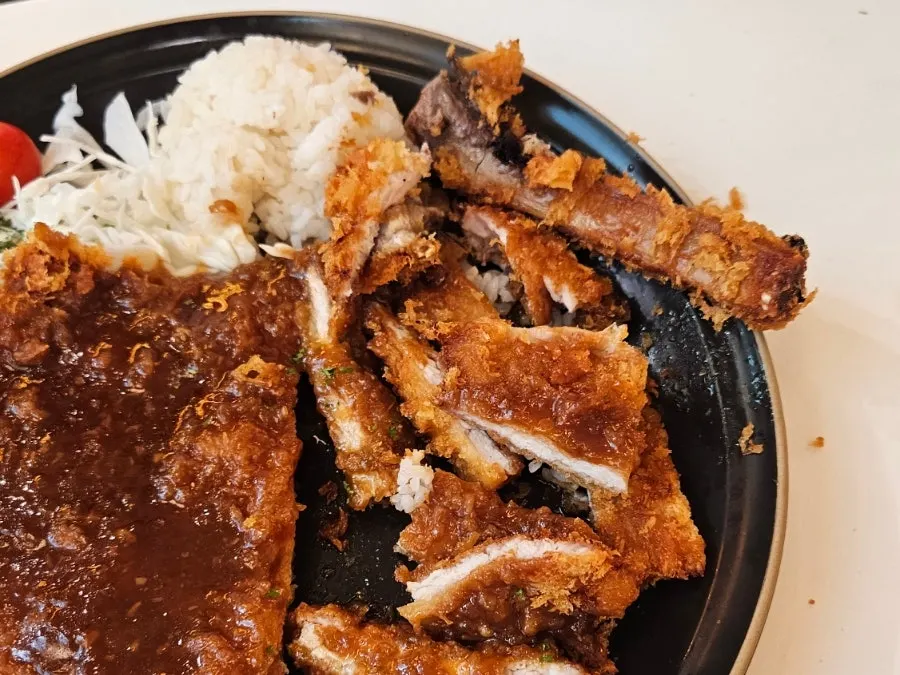 Tongs and scissors placed alongside the bone-in tonkatsu