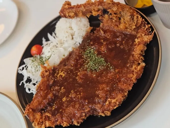 Cutting into the bone-in tonkatsu