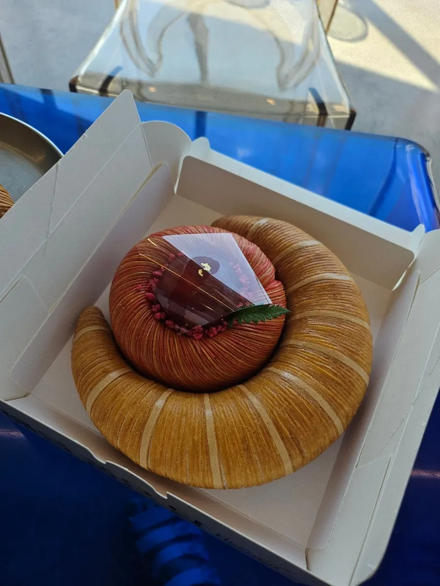 Coffee and bakery items on a table by the window facing the Nakdong River