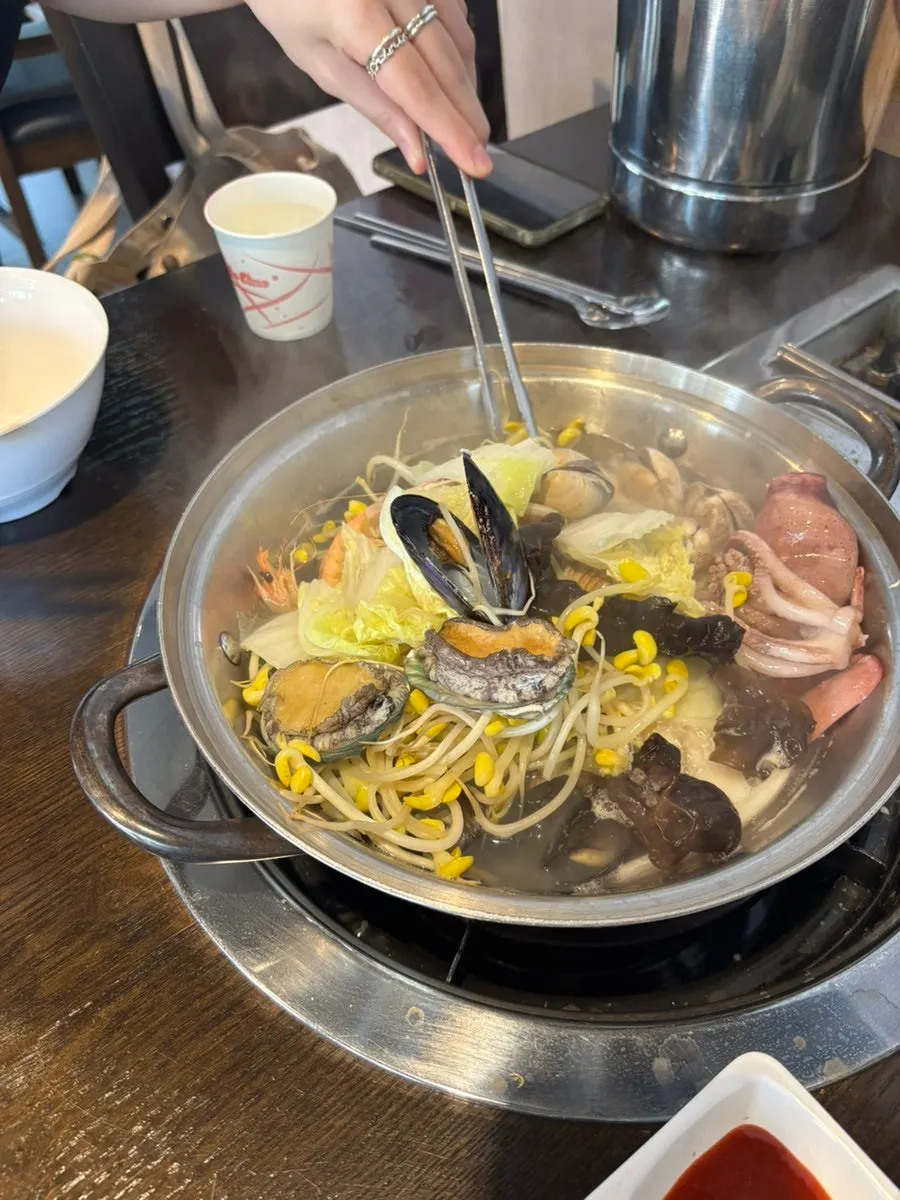 Open clams and cooked squid in the pot