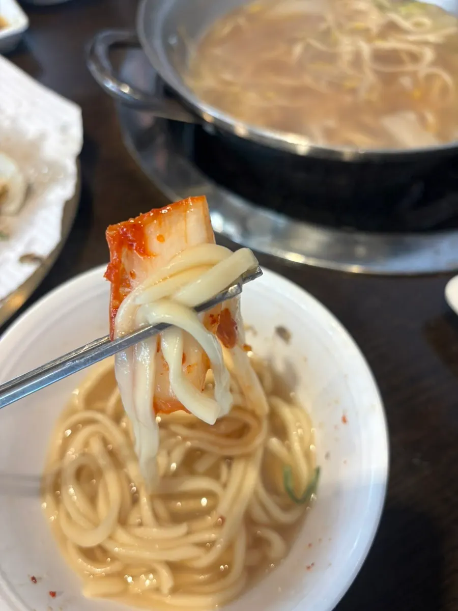 Kalguksu noodles simmering in the clear broth
