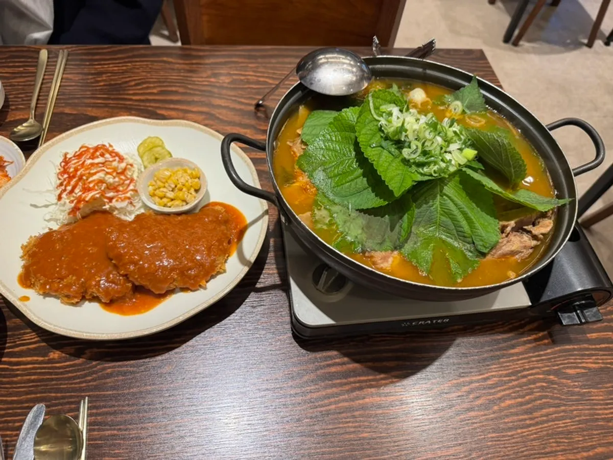 Full table spread of gamjatang small and hand-breaded pork cutlet