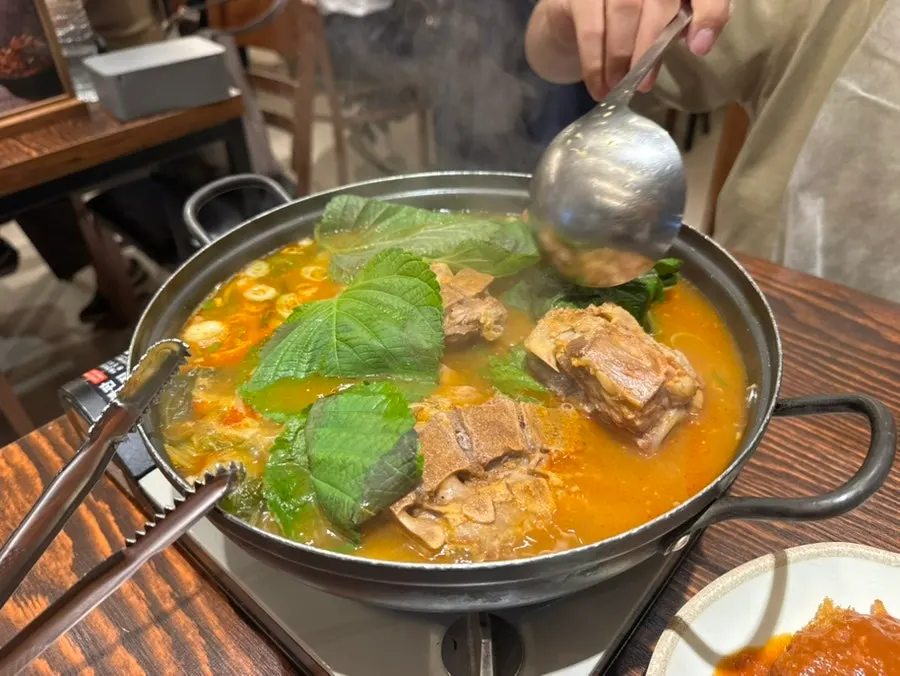 Deepened gamjatang broth served with a bowl of rice