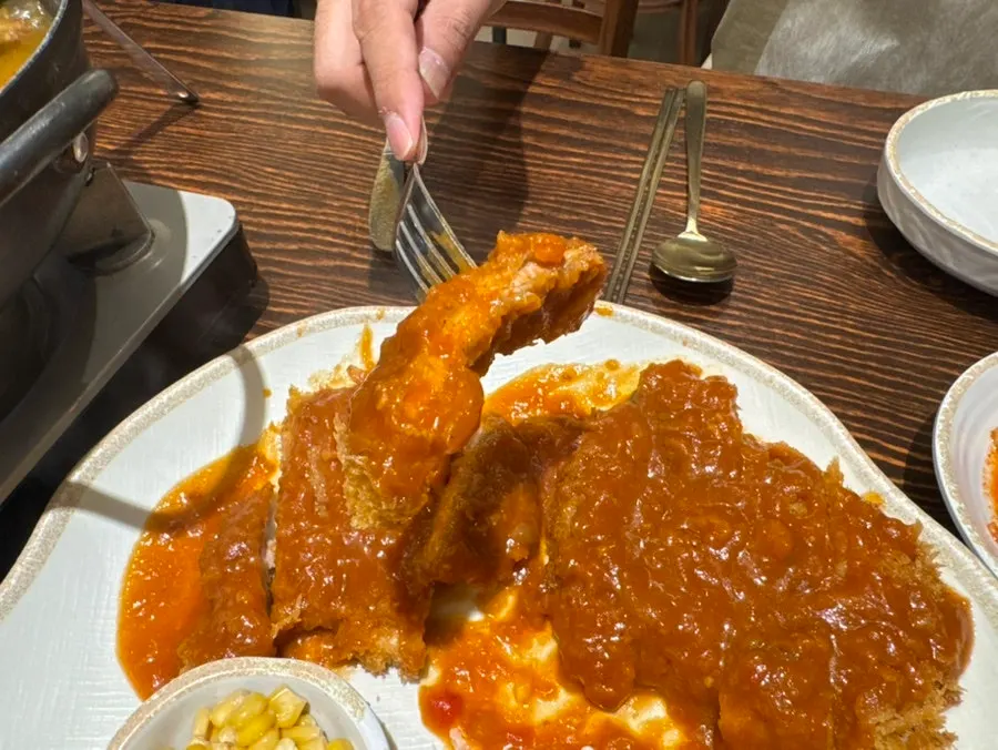 A crispy piece of pork cutlet picked up with chopsticks