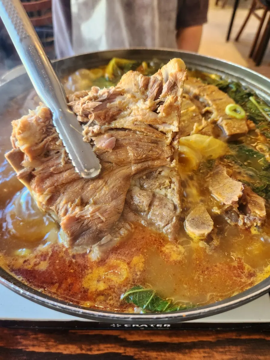 Bubbling gamjatang broth with perilla leaves