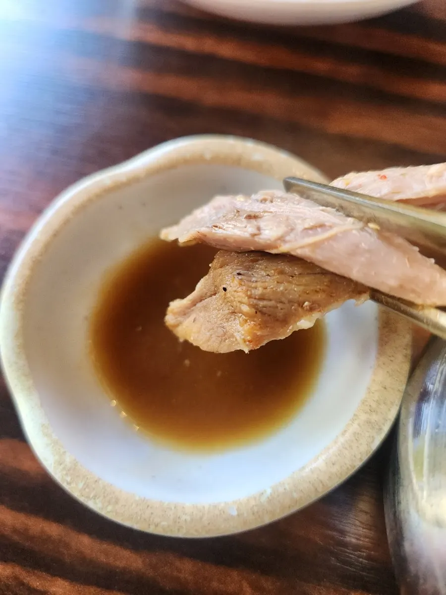 A piece of pork picked off the bone in the gamjatang