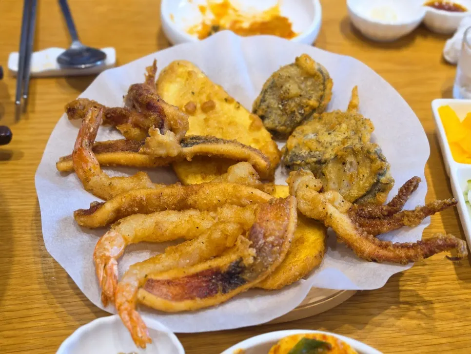 A bite of tteokbokki lifted up on chopsticks