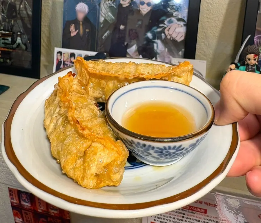 A plate of gyoza with dipping sauce