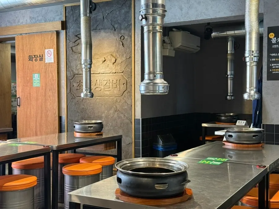 Interior of Choryang Saenggalbi with round stainless steel tables