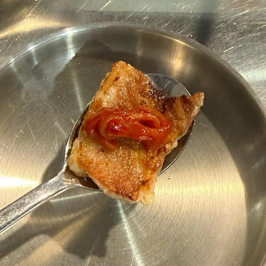 A piece of meat topped with scallop jeotgal