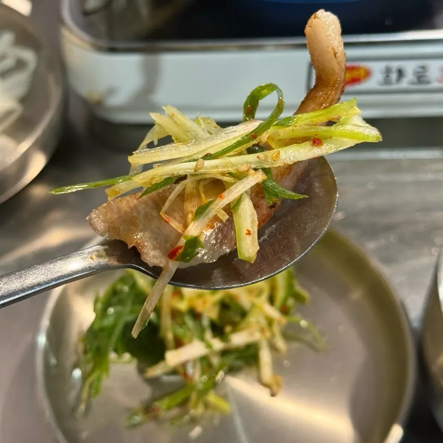A lettuce wrap with meat and jeotgal on top