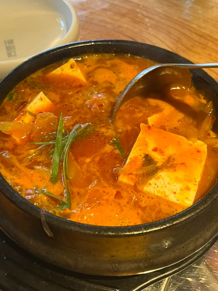 A piece of ogyeopsal wrapped with side dishes
