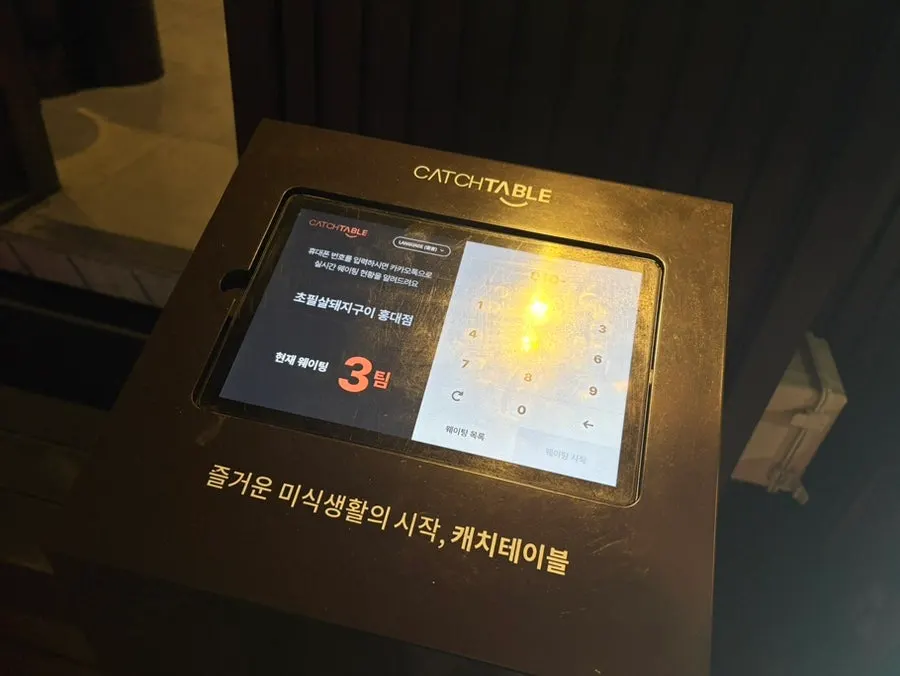 Exterior of Chopilsal Pork Grill Hongdae Branch with its neon sign lit up