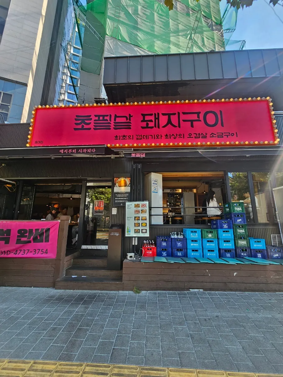 Restaurant exterior with a theater-style sign lit by yellow lights