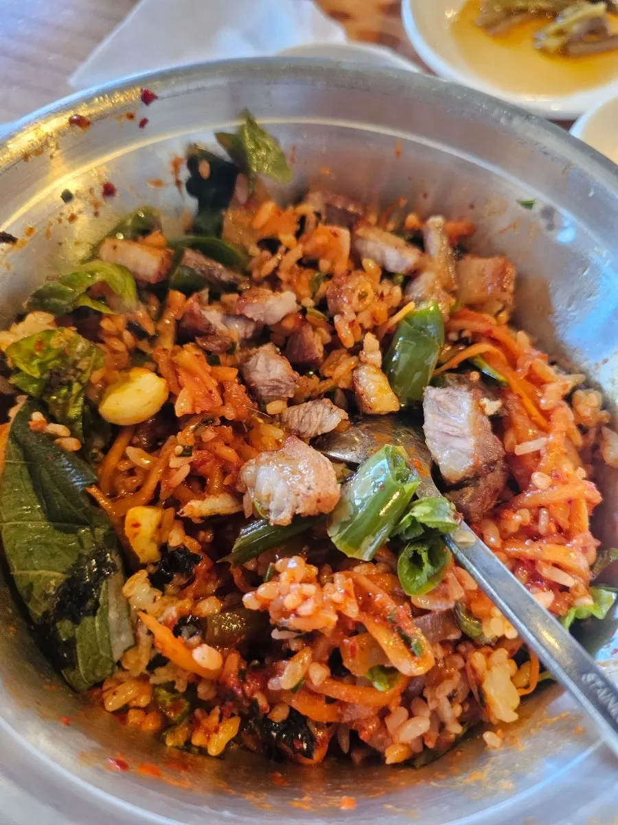 Spicy radish rice bowl mixed with lettuce wraps and side dishes