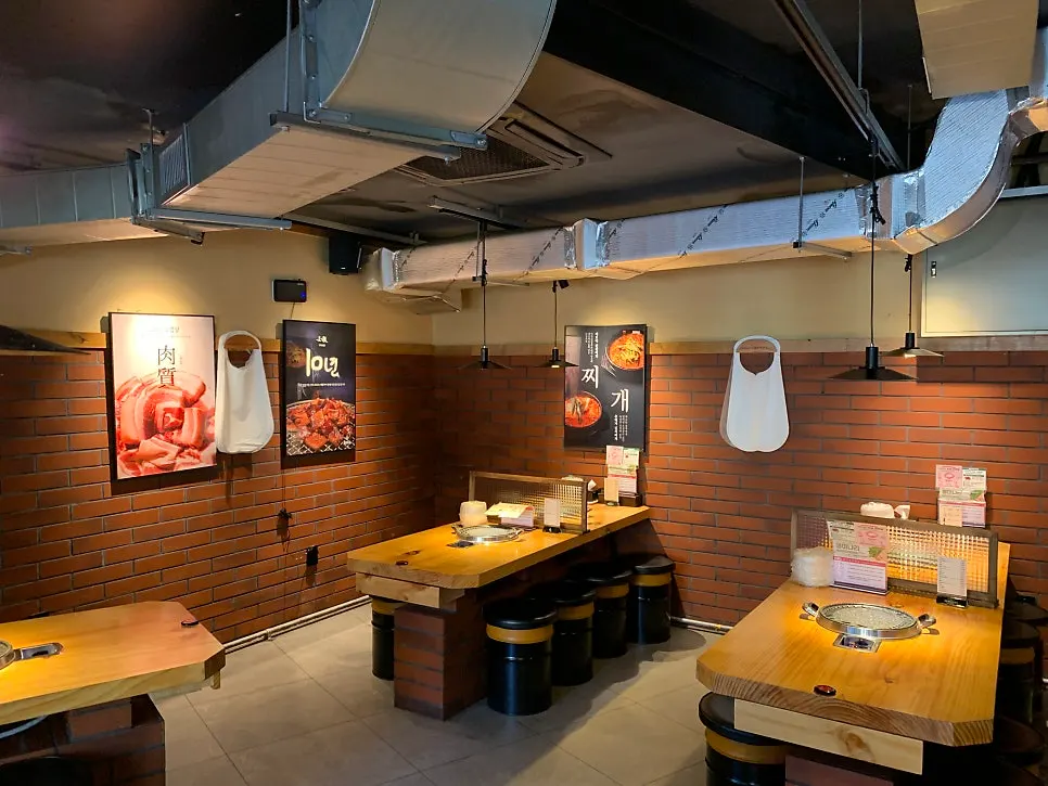 Red brick and wood-tone interior of Chopilsal Pork Grill Hongdae Branch