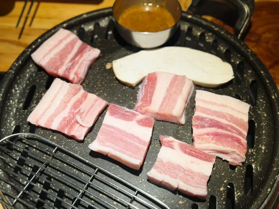 테이블에 세팅된 오겹살과 반찬 한 상