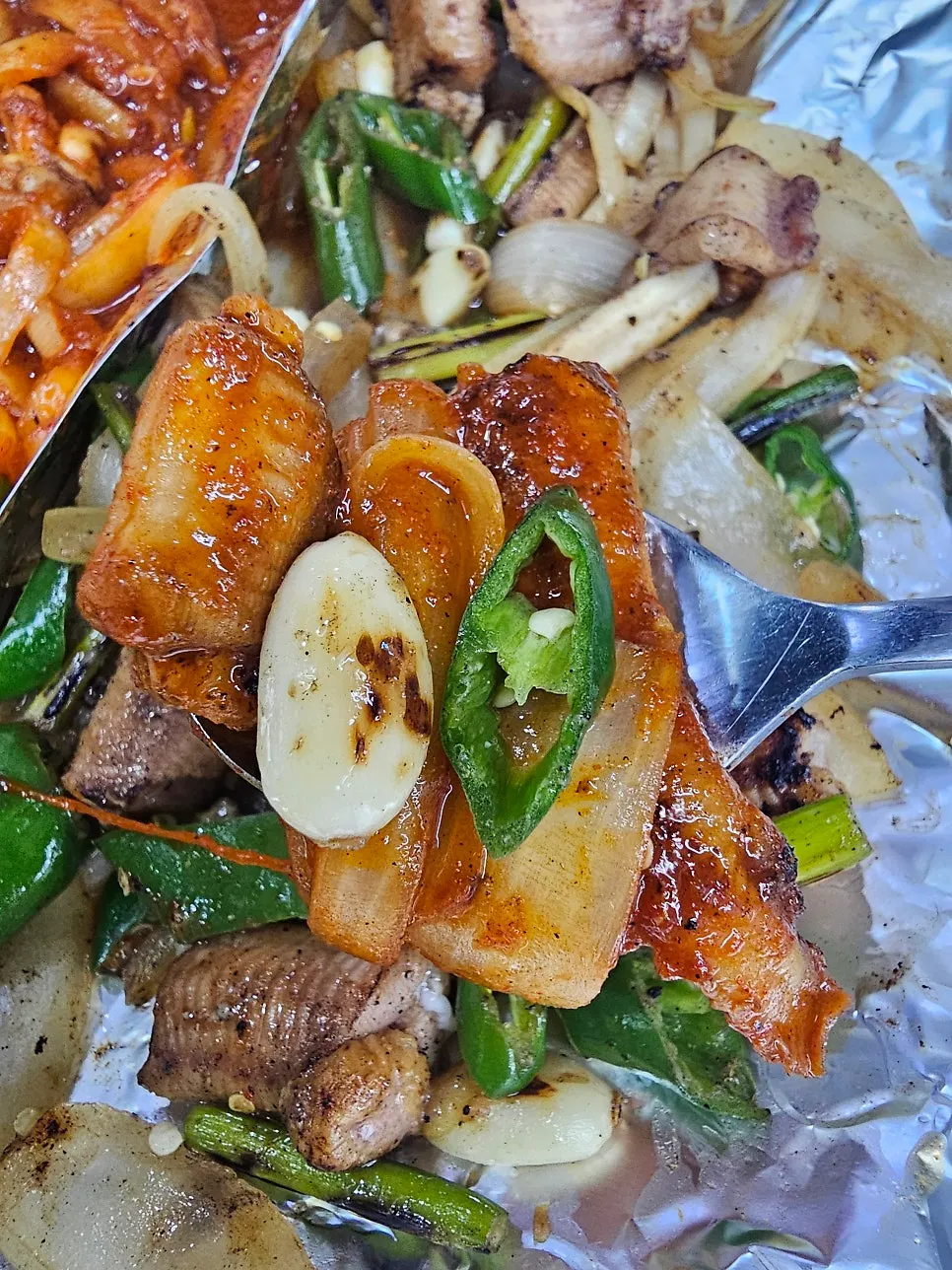 A spoonful of kkomjangeo and vegetables