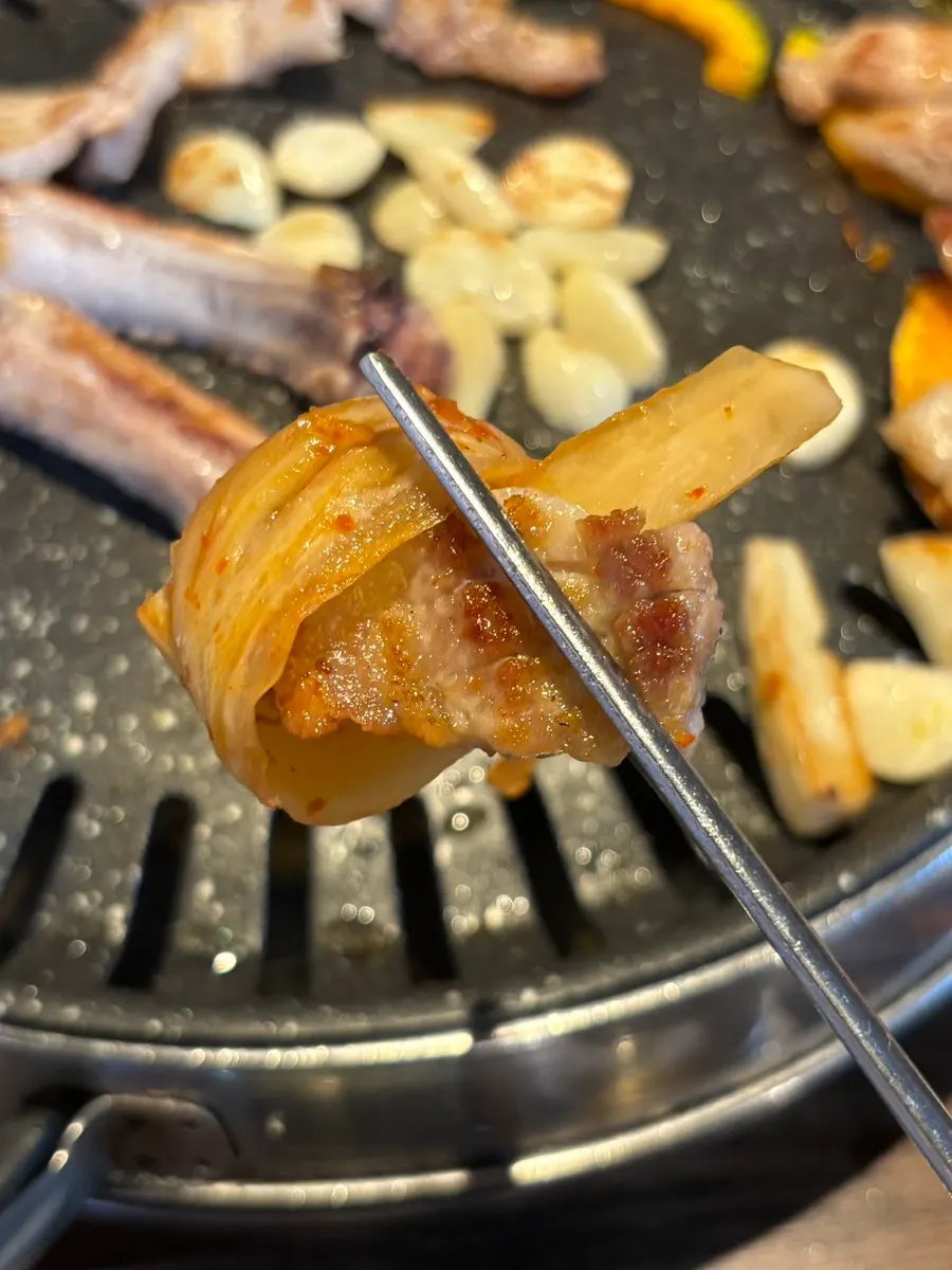A piece of raw pork rib dipped in salt from Choryang Hyeongje Galbi
