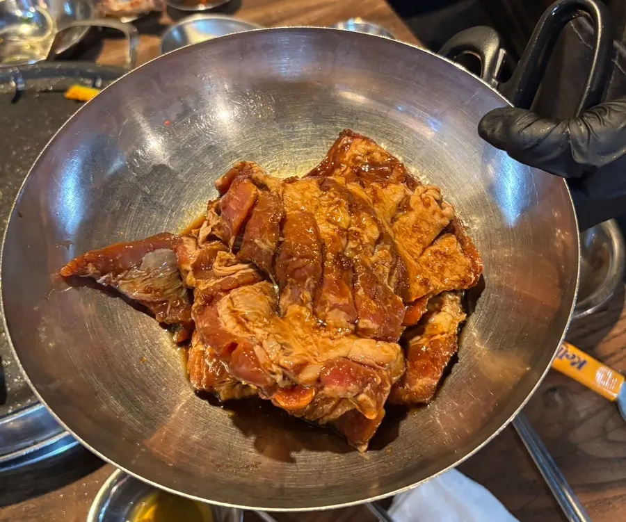 Two servings of raw marinated pork rib meat before cooking