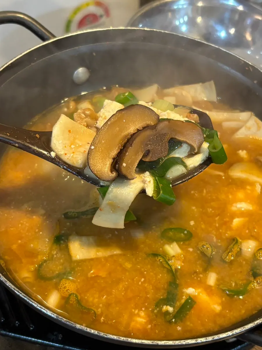Rich doenjang jjigae full of tofu and mushrooms