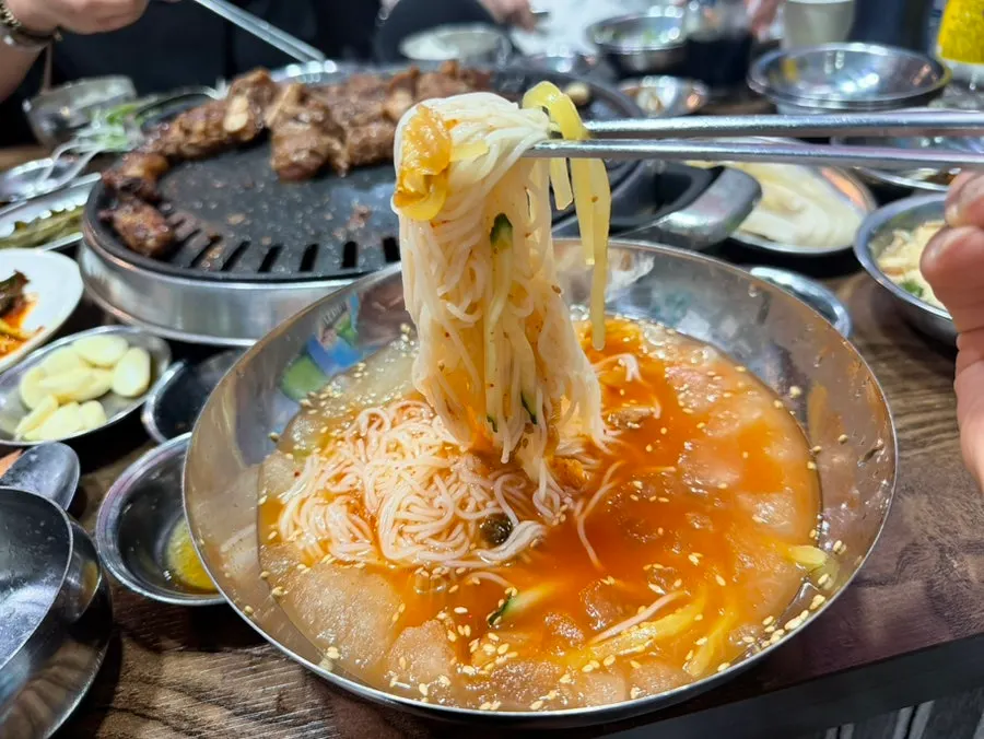Cold kimchi noodle soup topped with thin ice