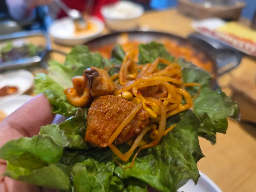 A spoonful loaded with pork, squid, and bean sprouts