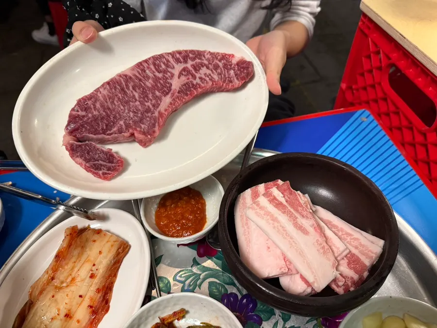 Table setting with ordered hanwoo striploin and frozen pork belly