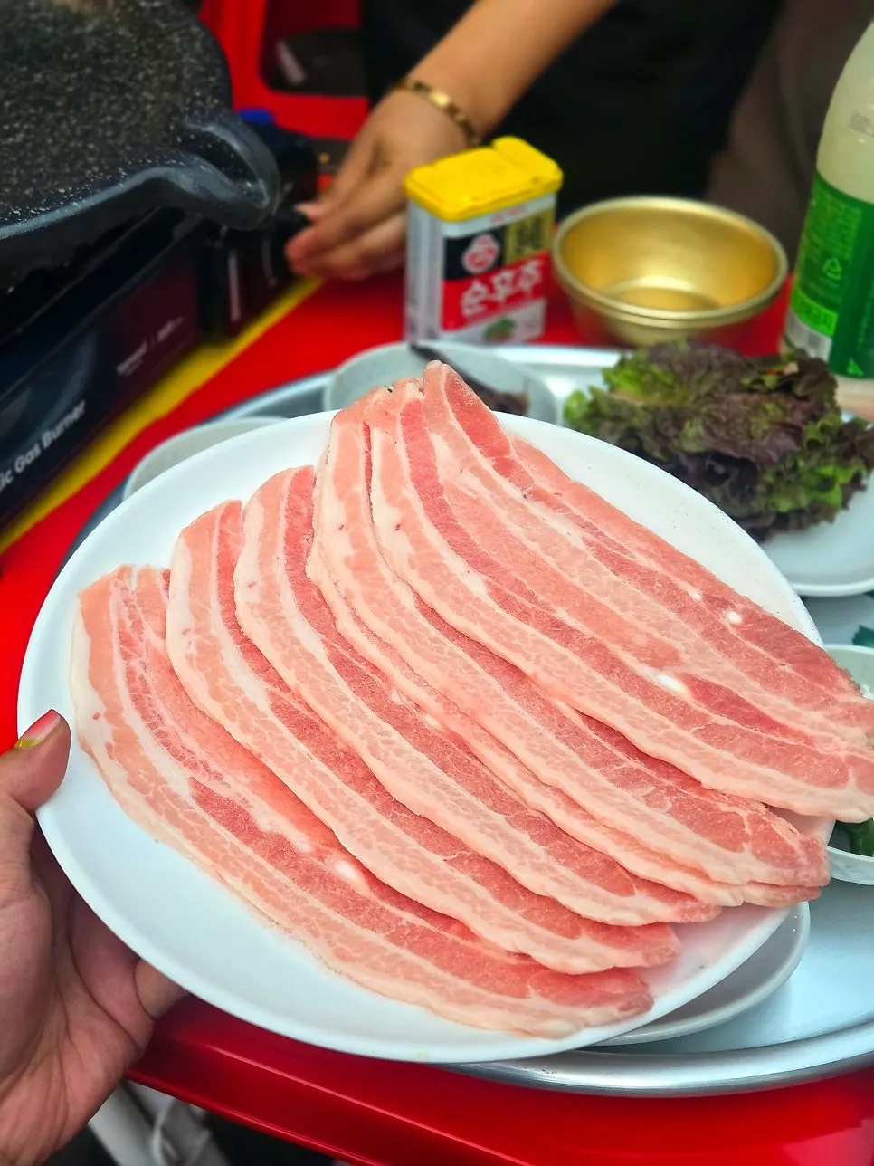 길게 담겨 나온 냉동삼겹살 2인분 한 접시