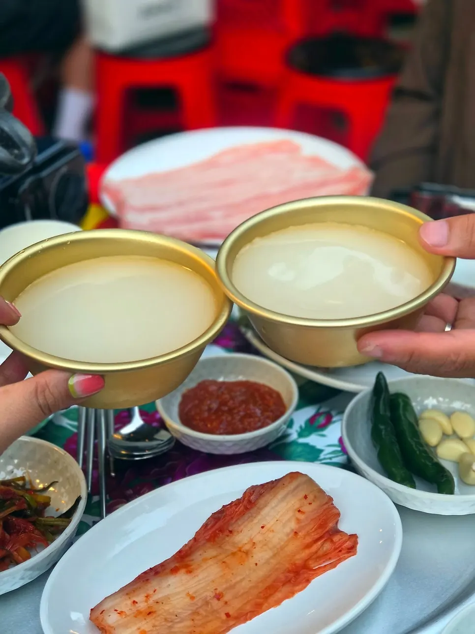 야외 테이블에 놓인 막걸리 한 병과 잔