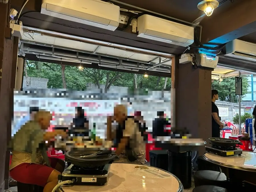 Simple outdoor tent tables and chairs set up in front of the shop