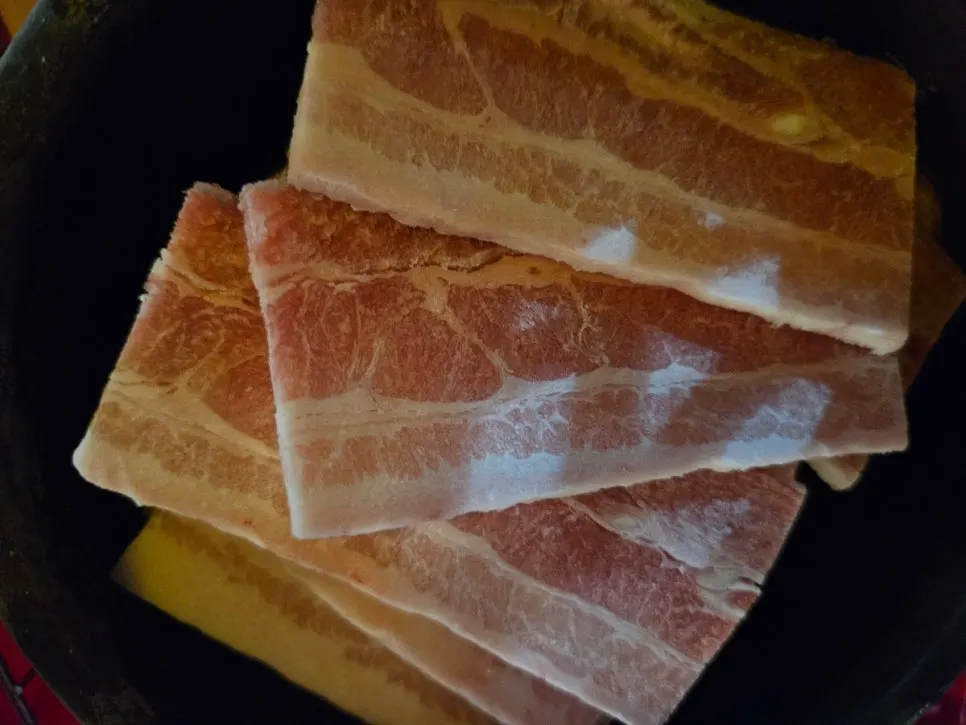 Frozen pork belly for two served in a jar-like container