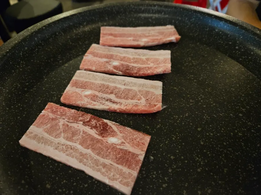 Frozen pork belly placed on the grill