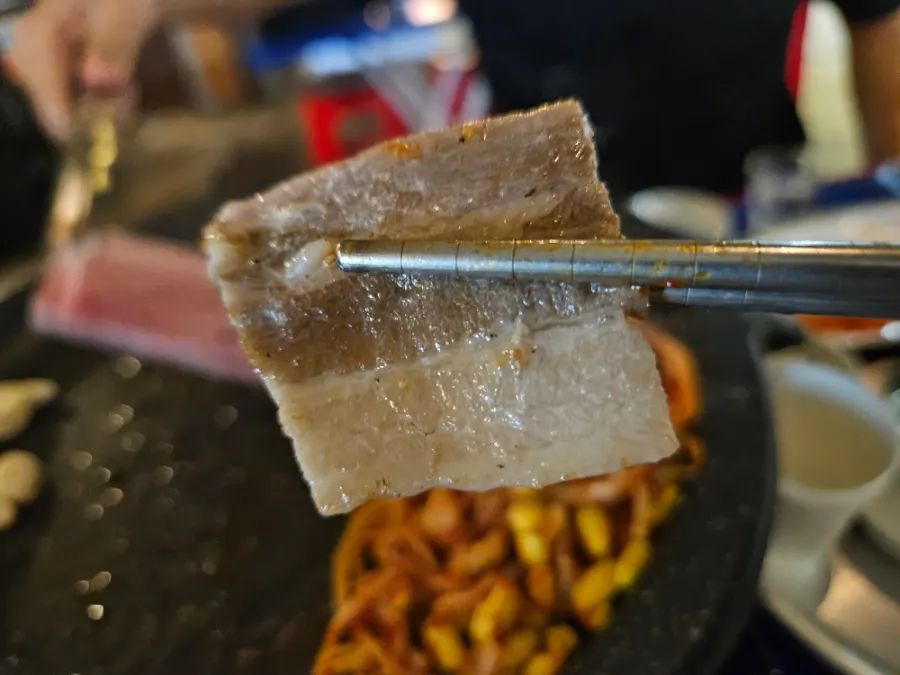 A pepper-sprinkled piece of grilled frozen pork belly