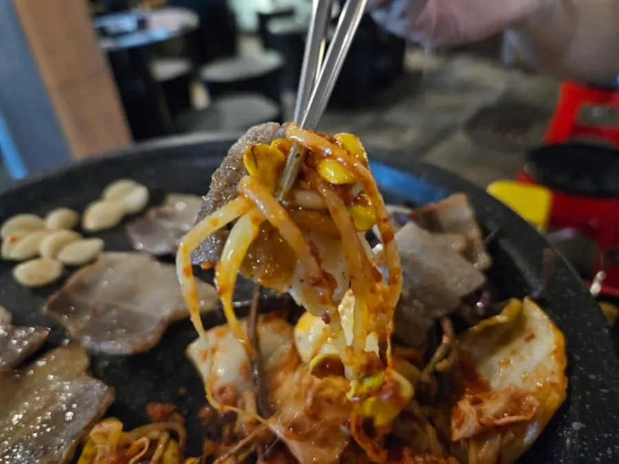 A piece of pork belly eaten with toppings