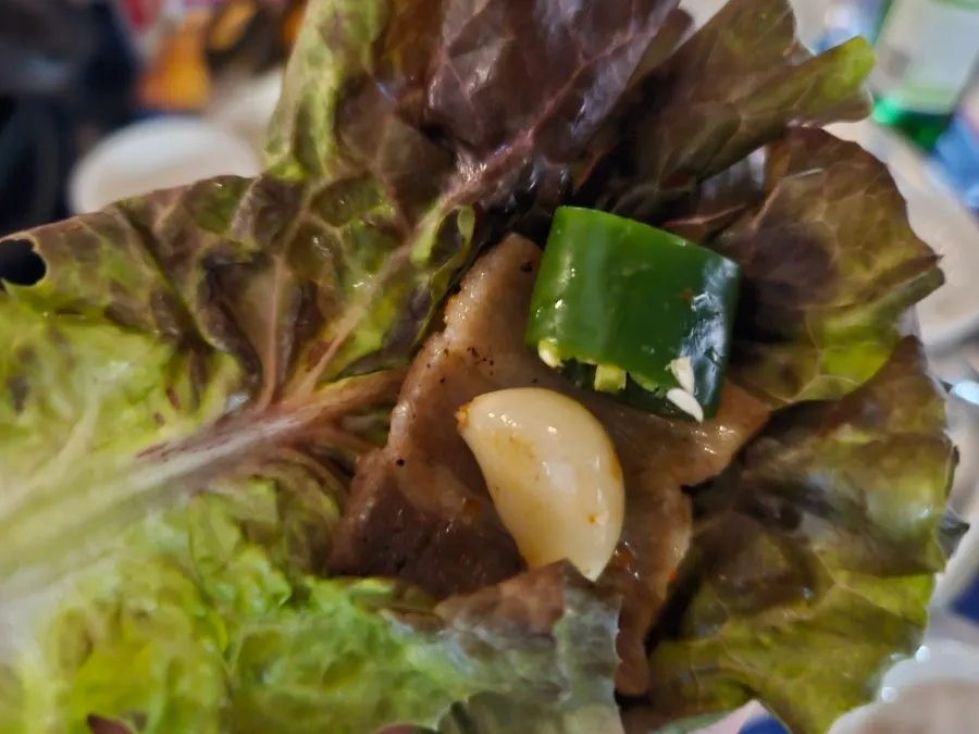 Grilled bracken fern and green onion kimchi piled on pork belly