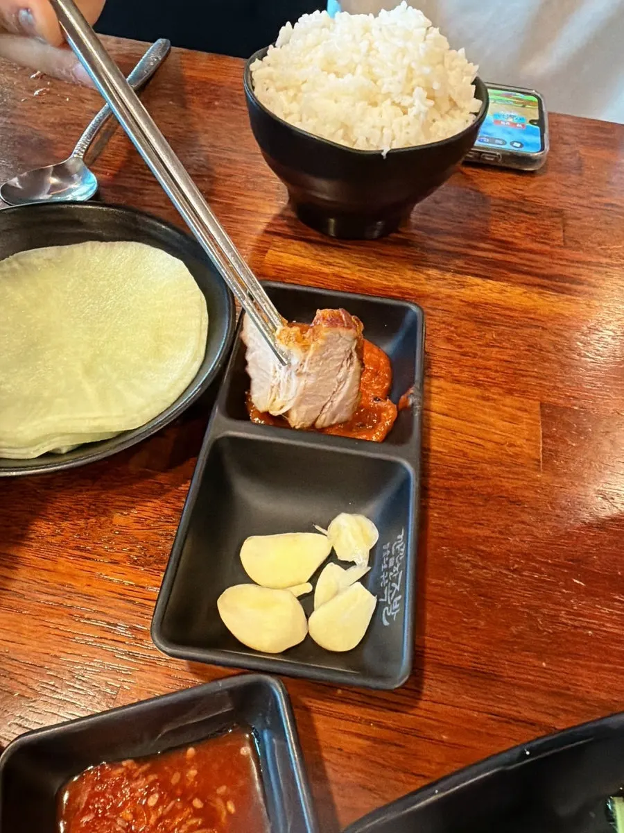 Table with bossam and a bowl of rice