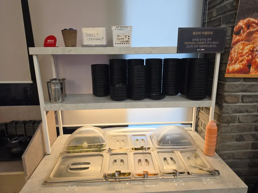 Self-bar stocked with lettuce, shredded radish, and other side dishes