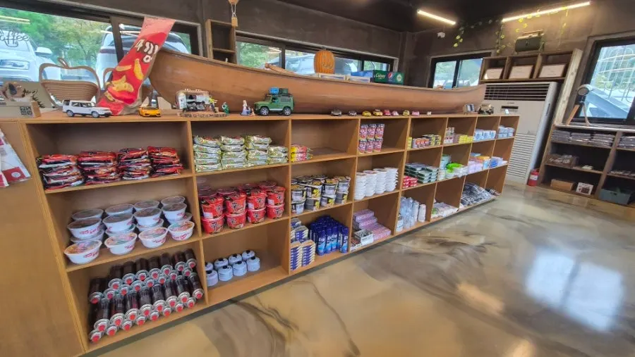 Campground store shelves with ramyeon, snacks, and ice cream