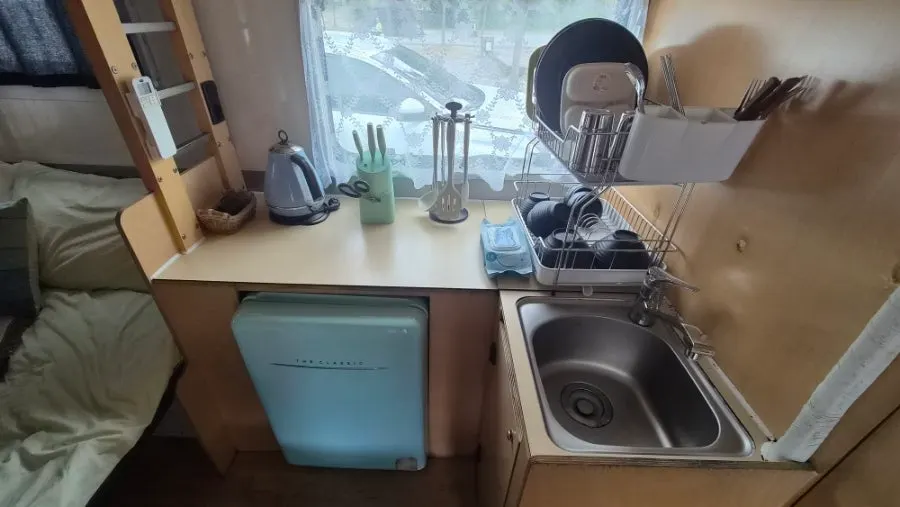 Caravan kitchen with fridge and dishware