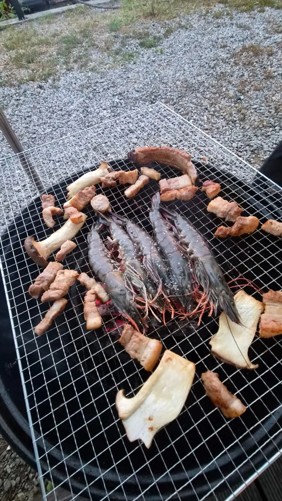 Whole shrimp grilling over charcoal