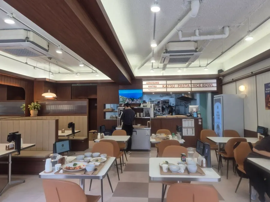 Interior of Jeongseong Katsu Chuncheon Hyoja Branch with wood-tone decor