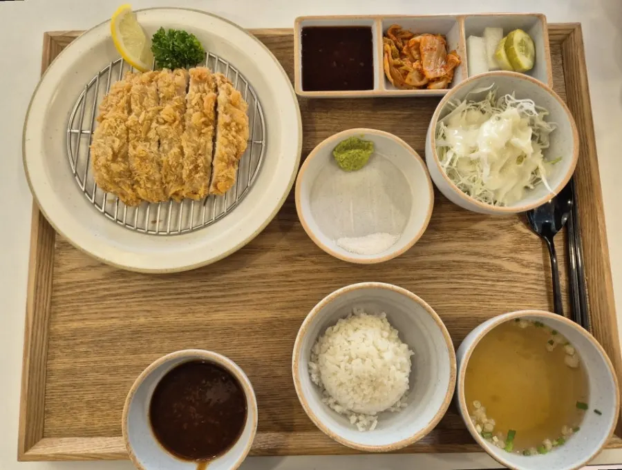 Two pork cutlet sets served with rice, soup, and salad