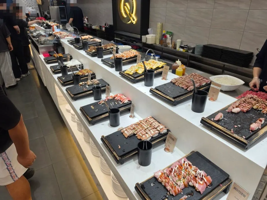 Buffet counter displaying various kinds of sushi