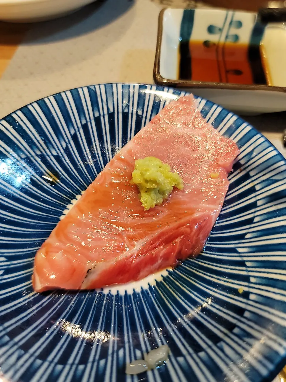 Round wooden tray with tuna cuts arranged by type