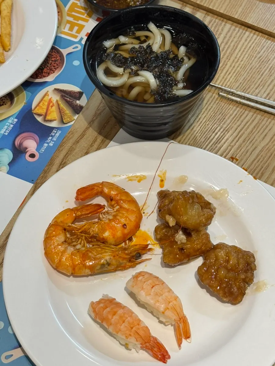A family's plate of sushi and fried food at QooQoo Chuncheon Branch